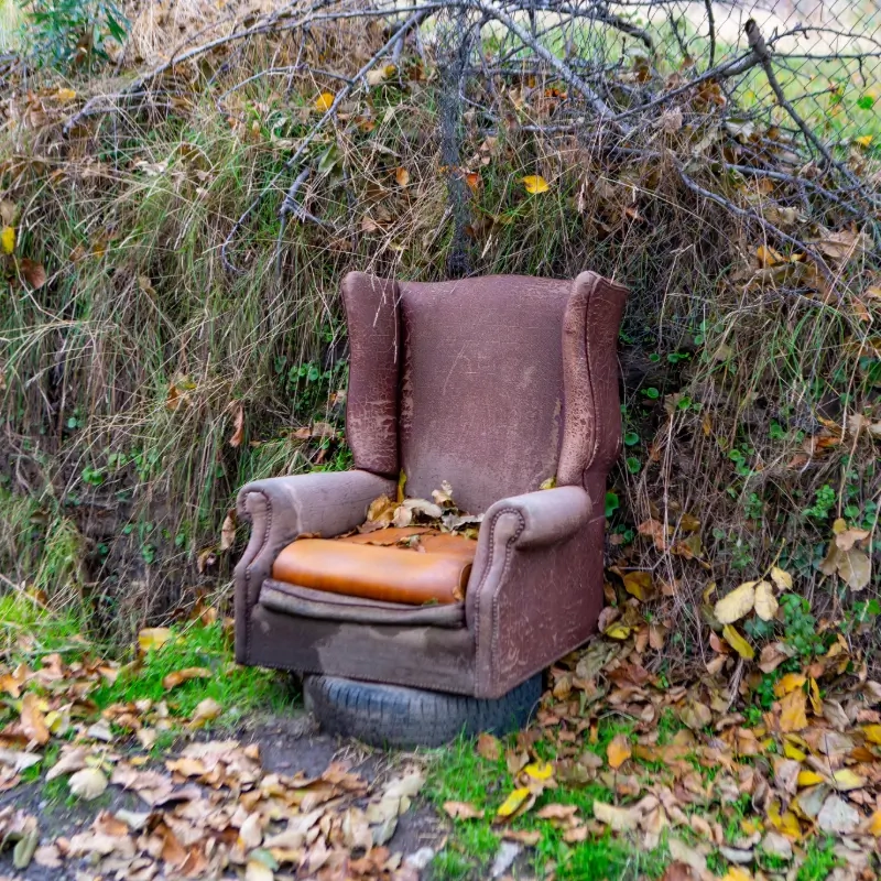 Fly-tipping of a chair in a layby next to a road